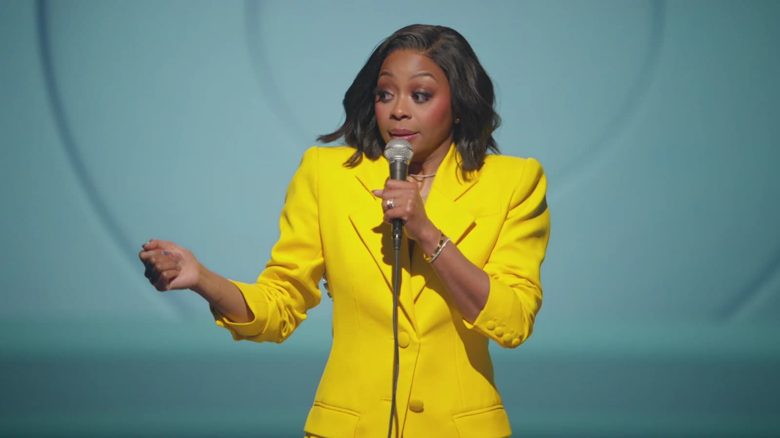 Bresha performing her LOL Live special in a bright yellow suit